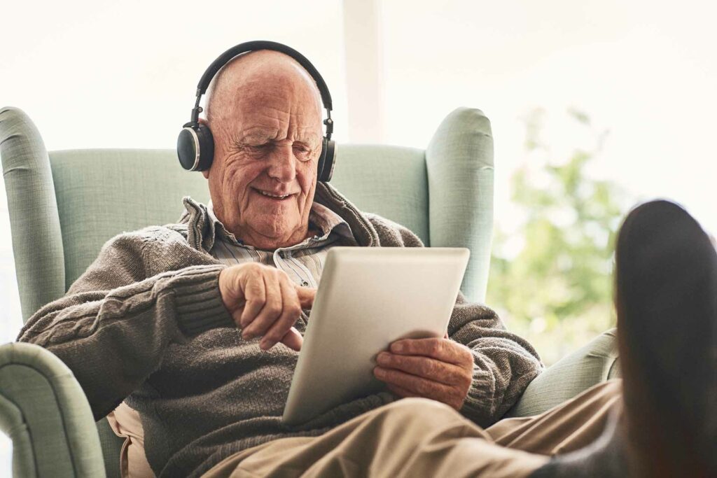 picture of Happy elderly man at home using digital tablet