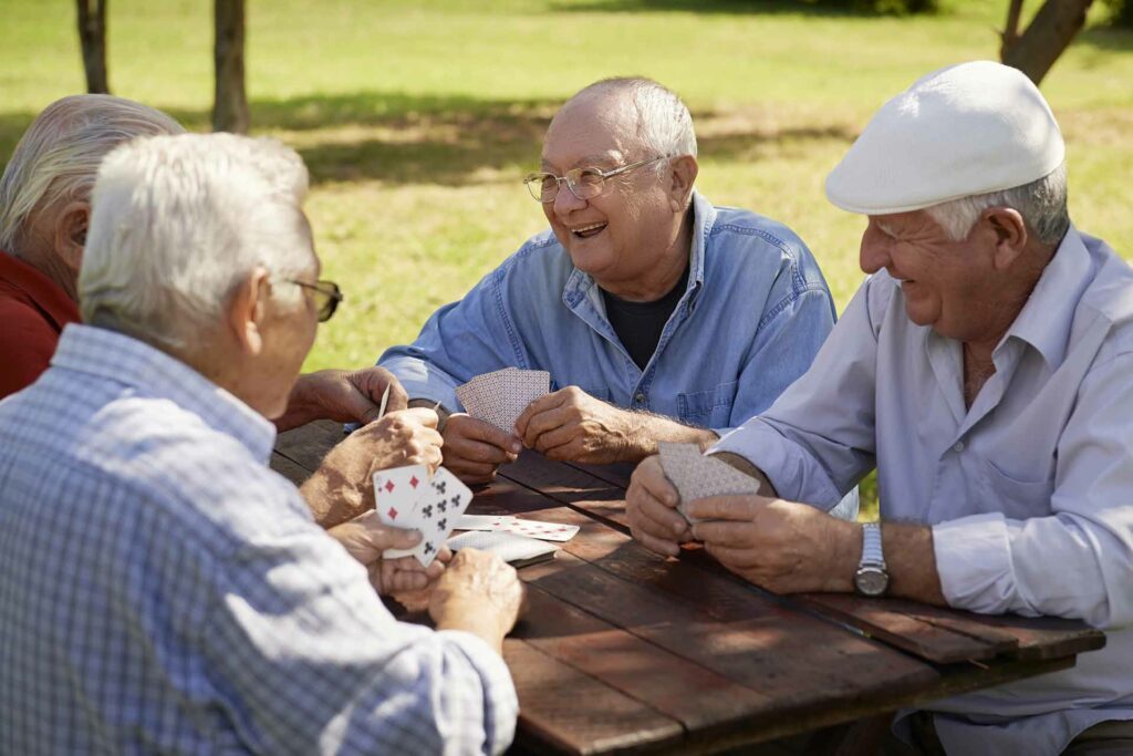 image of Group of senior men, smiling and playing cards at the park