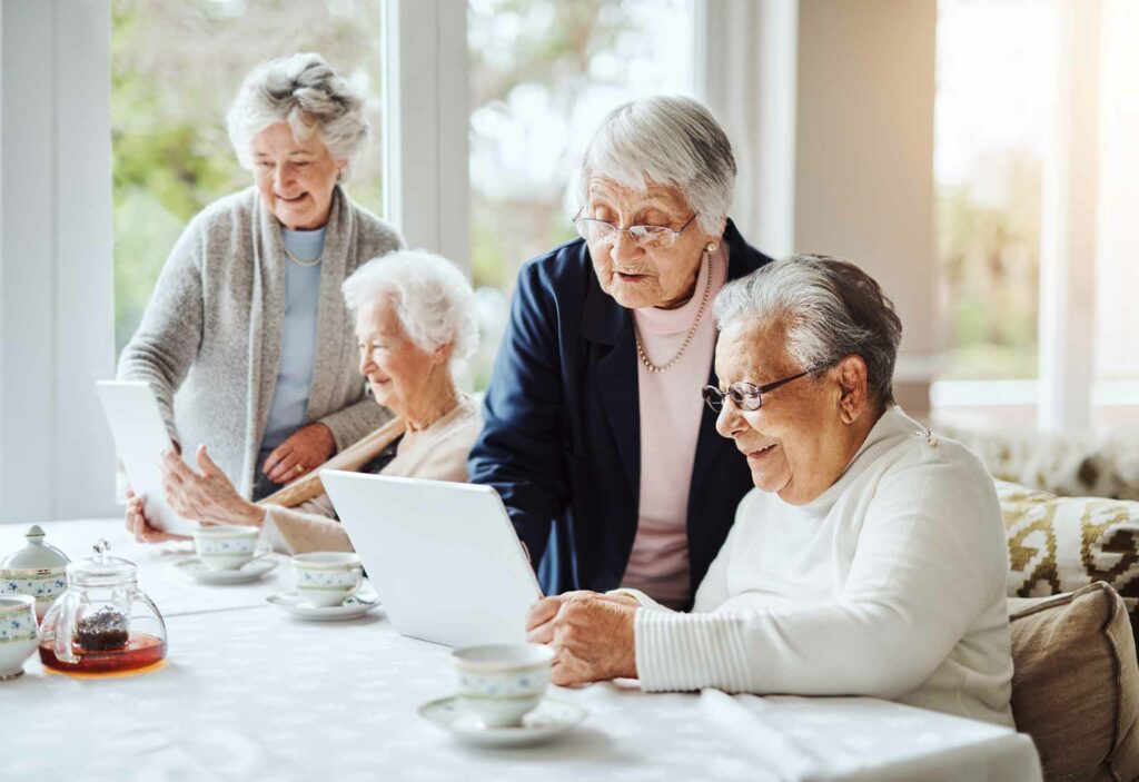 picture of group of senior women using a digital tablet together at a retirement home